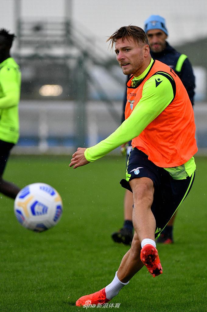 两名后卫在体能教练的监督下进行折返跑冲刺，他们的面部肌肉因发力而紧绷，汗水沿着发梢甩出一道晶莹的弧线，背景里模糊的队友正在做拉伸，动静之间尽显职业足球的严苛。