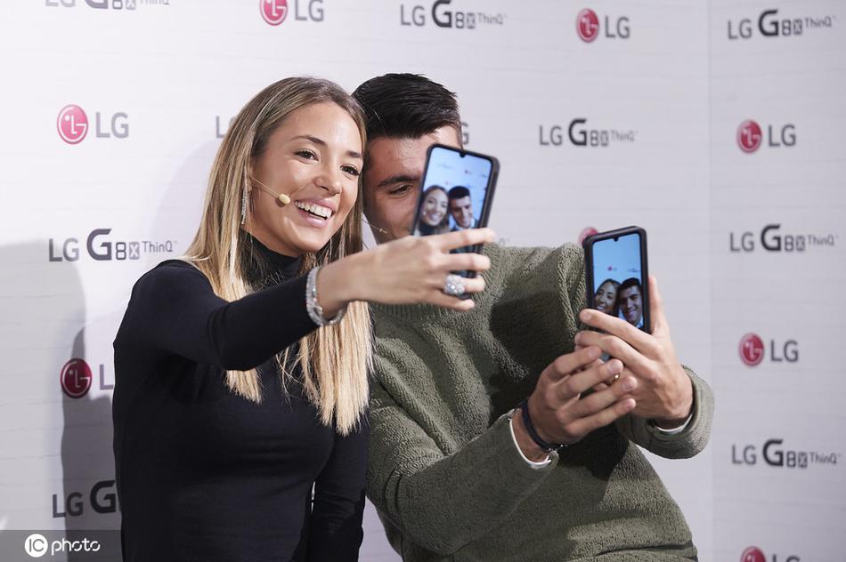 活动现场的莫拉塔夫妇与品牌高层互动，莫拉塔专注倾听时，坎佩洛侧身微笑相伴，夫妻二人共同为品牌站台的画面显得专业又温馨。