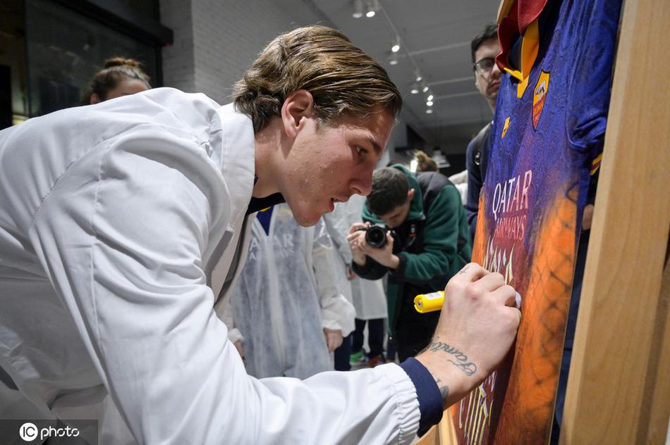 两名球员并肩而立，共同讨论着眼前的画作，一人正在为画面增添一抹亮色，另一人在旁出谋划策，画面充满了团队协作的温情与创作的快乐。