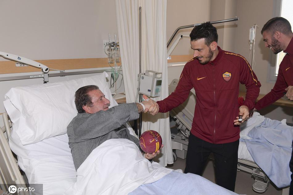 罗马球员弗洛伦齐俯身倾听，将签名礼物递到病床上的小患者手中，眼神中满是关切与鼓励，温暖了整个病房。