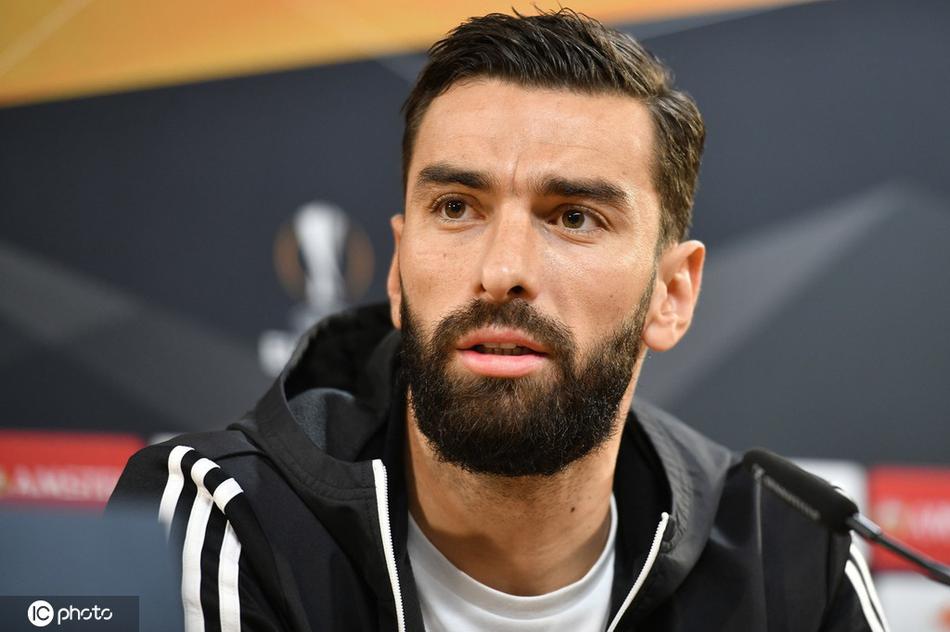 狼队球员在布拉加进行踩场训练，一名球员正在雨中带球绕杆，水花在灯光下溅起，队友们在背景中拉伸热身，展现出大战前的紧张备战氛围。