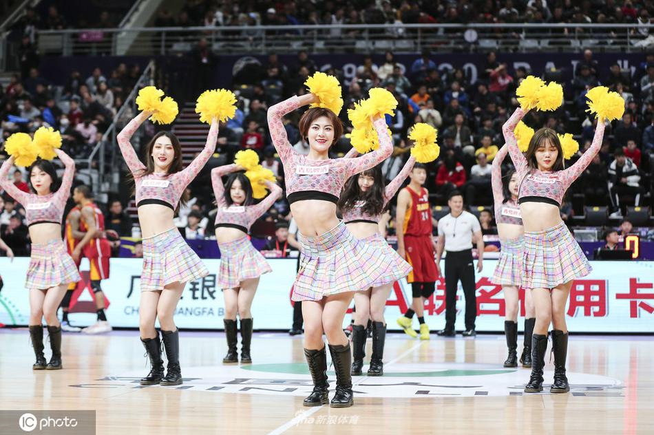身着一袭亮眼红色旗袍的啦啦宝贝，在球场上翩翩起舞，裙摆随着动作轻盈摇曳，仿佛一朵盛开的牡丹