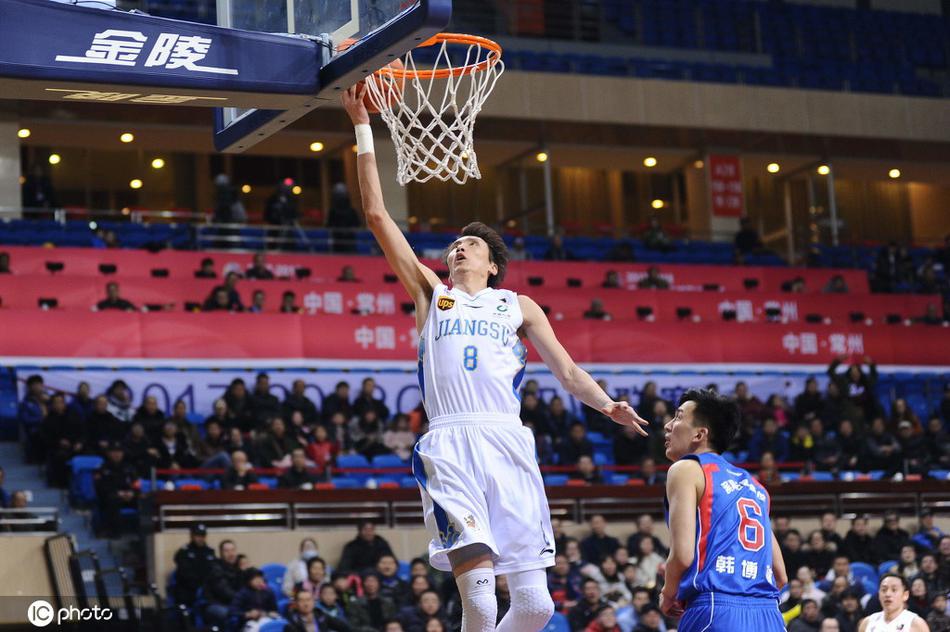 易立紧咬牙关运球突破，面露坚毅之色，汗水在灯光下闪烁，展现出老将不服输的拼搏精神。