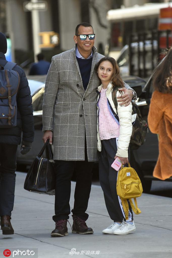 罗德里格斯温柔地搂着女儿的肩膀，两人在纽约街头相视而笑，背景是城市特有的活力与喧嚣，但他们的眼中只有彼此，温馨的氛围仿佛让周围的一切都静止了。