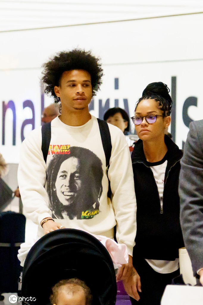 在人流稀疏的机场通道中，萨内独自推着满载的行李车大步流星，简洁的白色T恤下是康复训练后愈发结实的身形。即便墨镜遮面，也难掩他神情中的那份专注与坚毅，仿佛这不是一次普通的乘机返程，而是他伤愈复出、重新夺回属于自己荣耀的起跑线。