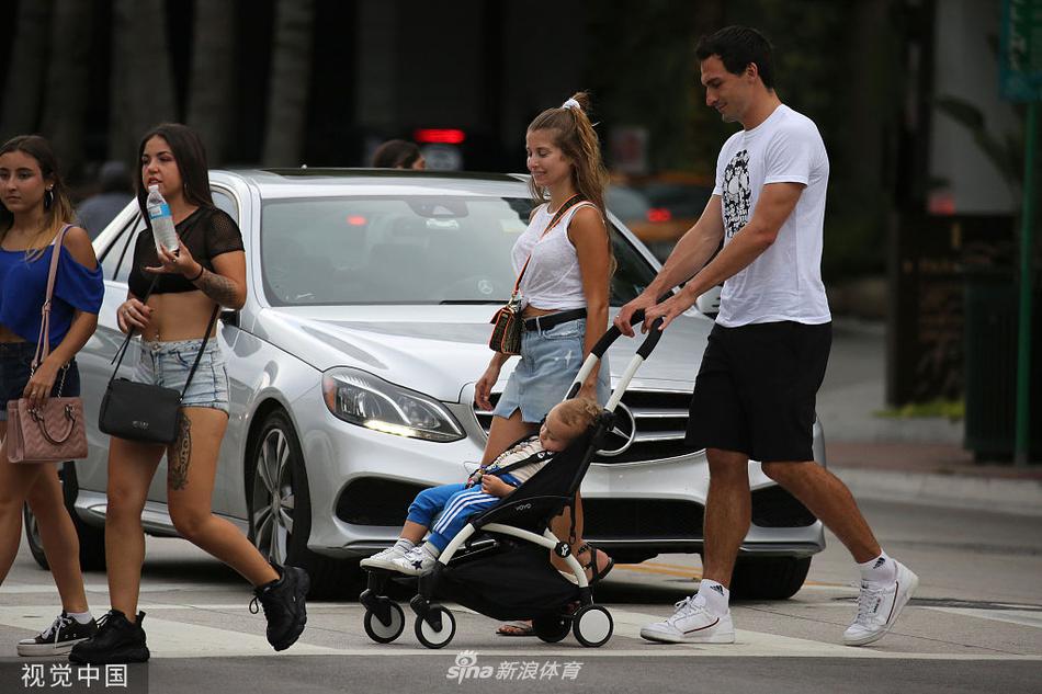 阳光洒在海滩上，胡梅尔斯温柔地抱着儿子，妻子凯茜依偎在他身旁，三人的笑容比身后的碧海蓝天还要灿烂，定格成一张完美的全家福。