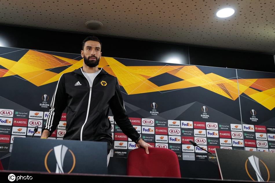 狼队主教练努诺-桑托在赛前新闻发布会上神情专注，身后的背景板映衬出布拉加雨夜的灯光，他的眼神中透露出对次日欧联杯关键战的坚定与思考。