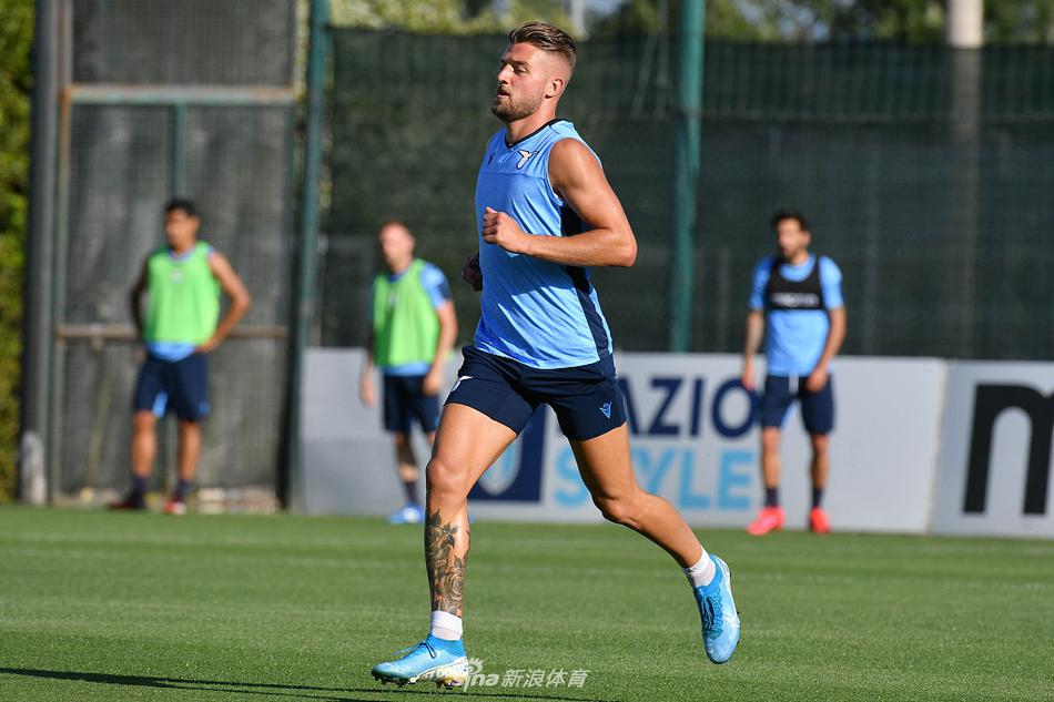 主帅小因西吉双手叉腰，神情专注地站在场边指挥着球队的合练，他的剪影与远处罗马的晴空构成一幅生动的足球备战图景。