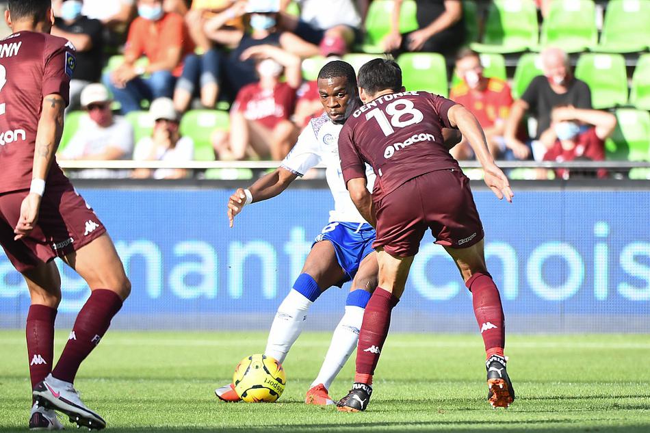 身披白色球衣的兰斯球员们围成一圈，神情凝重地商讨着对策，他们刚遭遇丢球打击，急需稳住阵脚，但场上少一人作战的劣势让他们的战术执行变得异常艰难。