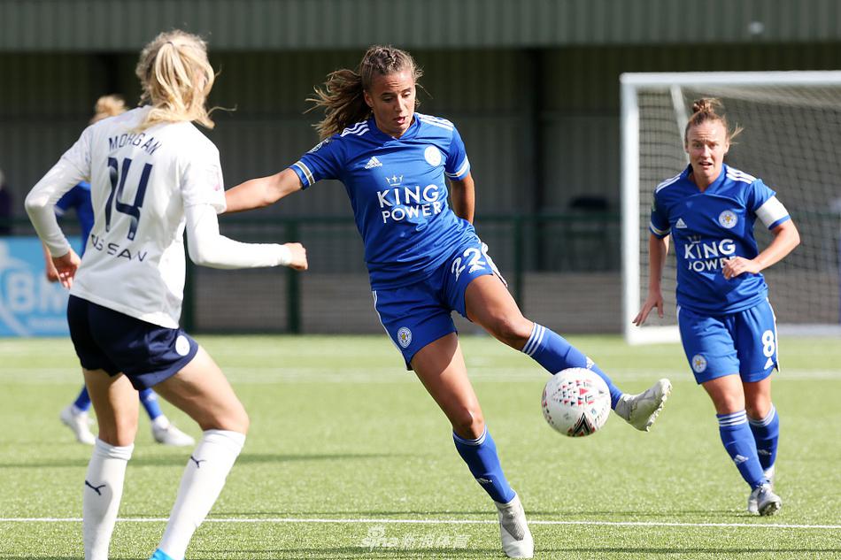 在一片混战中，身穿白色球衣的莱斯特城女足球员高高跃起，与曼城后卫激烈争顶，展现了她们为缩小比分差距而不懈拼搏的决心。