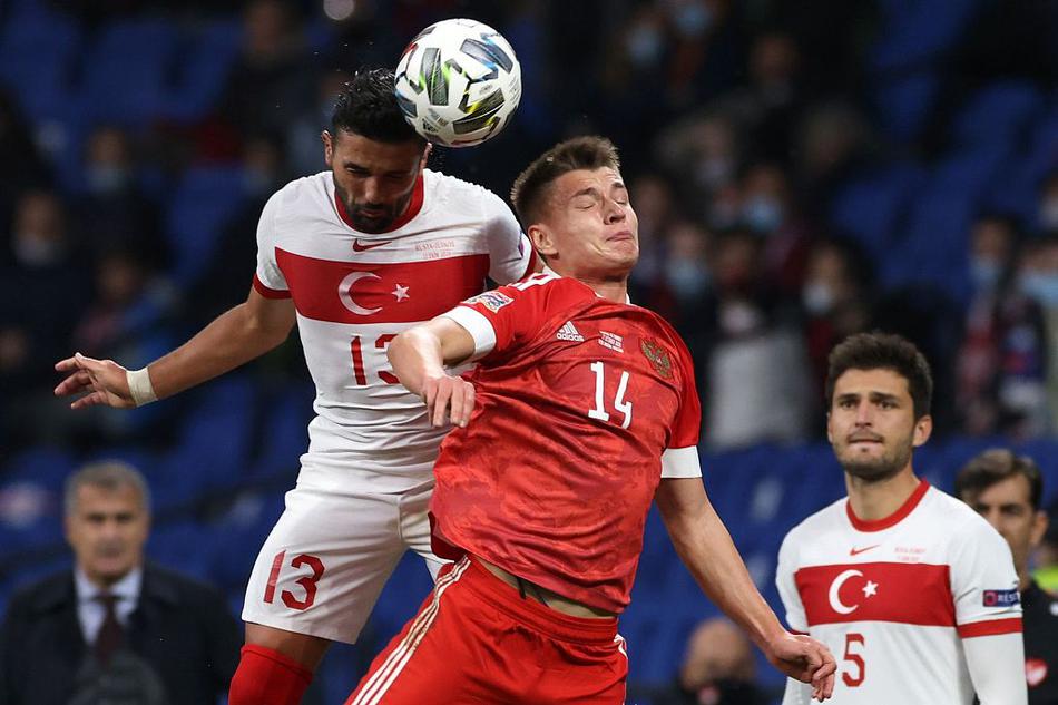 俄罗斯高中锋久巴在土耳其防线夹击中高高跃起，试图用他标志性的头球攻门撕裂对手的密集防守，这一刻他是莫斯科雨夜中最具威胁的空中堡垒。