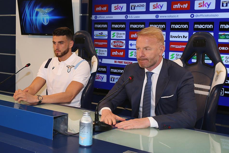 韦达特·穆里奇身披拉齐奥战袍，在镁光灯下展现标志性微笑，身旁的体育总监塔雷眼神中满是对这位新援的期待与信任。