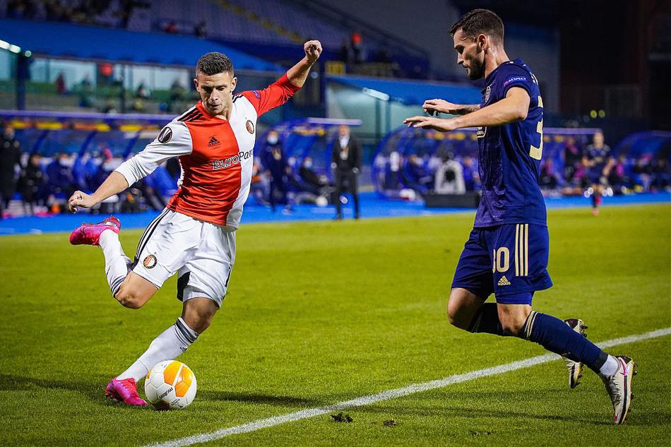 灯光照耀下的马克西米尔球场，一位萨格勒布迪纳摩的攻击手在对方禁区内背身拿球，两名费耶诺德防守球员从前后两个方向对其进行夹击，三人肌肉紧绷，力量与意志的对抗在此刻凝固。