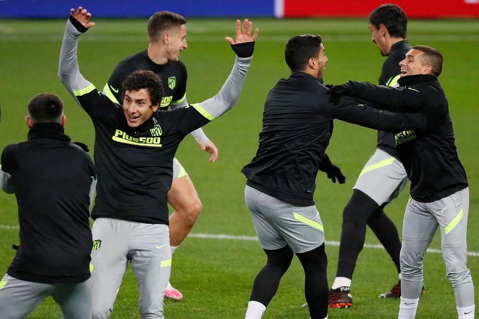 训练场上，一名马竞球员正进行高强度冲刺，飞溅起的人造草屑与身后模糊的莫斯科郊外建筑群，构成了一幅动感十足的备战画卷。