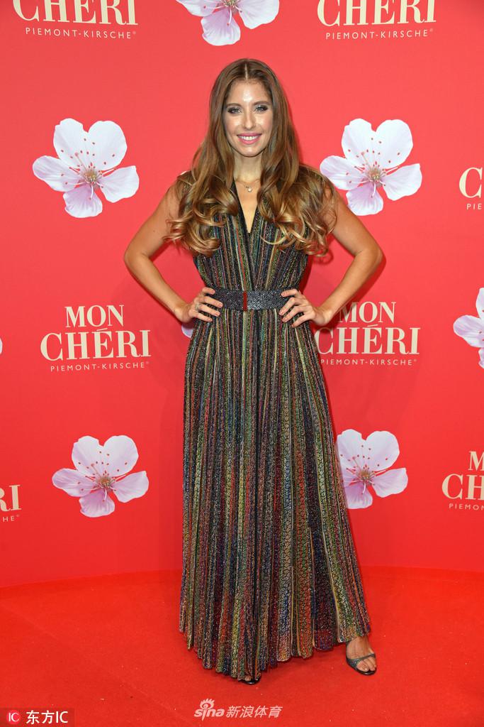 活动现场，凯茜侧身回眸，裙摆随着动作轻轻摆动，精致的妆容衬托出她自信而迷人的神态