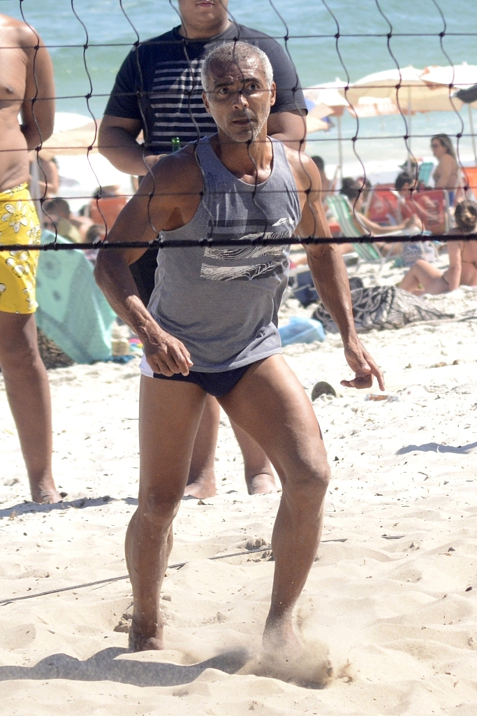 罗马里奥高高跃起，在海滩阳光下舒展手臂，准备以一记势大力沉的扣杀终结回合，眼神中满是当年在禁区内一击必杀的专注与锐利。