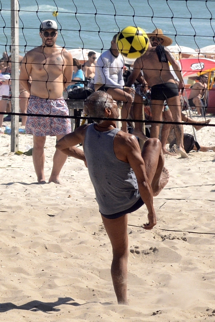 罗马里奥一个漂亮的鱼跃救球后，从沙滩上站起，脸上带着一丝狡黠而满足的微笑，仿佛在告诉对手：想赢我，可没那么容易。满身的沙粒是他全力以赴的最佳证明。