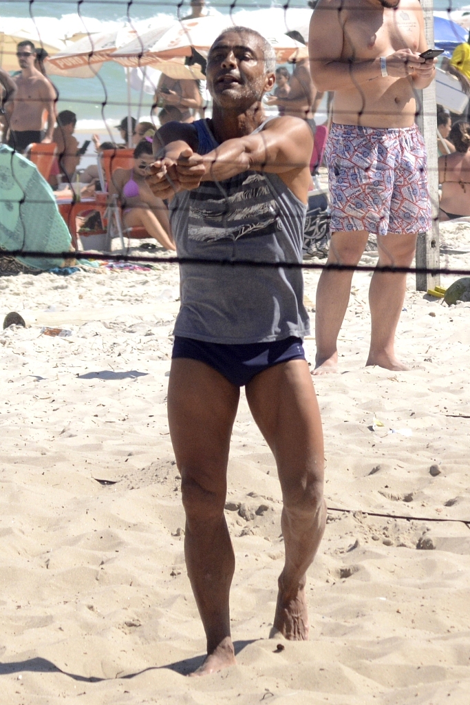 罗马里奥俯身将沙滩排球稳稳垫起，动作舒展而放松，脸上带着从容的微笑。身后是湛蓝的大海和天空，这幅画面完美展现了这位传奇球星退役后惬意又充满活力的生活。