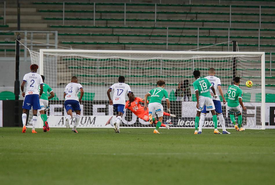 圣埃蒂安球员们紧紧拥抱在一起，庆祝卡马拉的进球，他们的笑容和绿色的球衣在灯光下闪耀，完美诠释了团队足球的魅力。