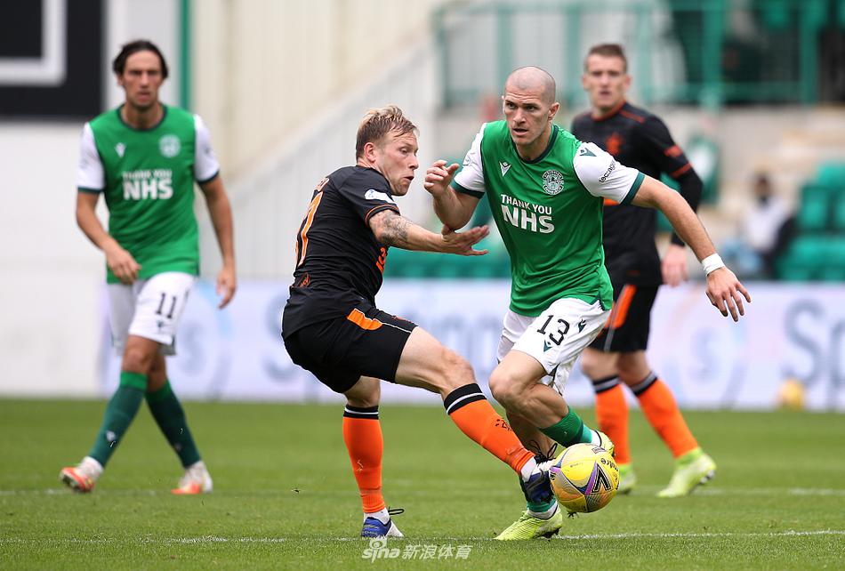 希伯尼安球员在进球后激情拥抱，他们围成一圈，脸上洋溢着不可思议的喜悦，背景是看台上挥舞着围巾的狂热球迷。