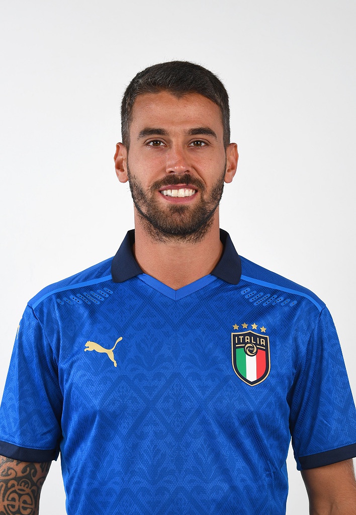 中场核心若日尼奥身着蓝色战袍，眼神深邃地凝视远方，举手投足间散发着指挥官的优雅与从容。