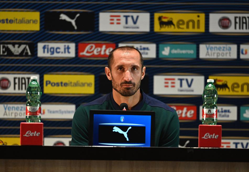 意大利足协工作人员在发布会现场调试设备，背后是欧国联官方标志，预示着新赛季的欧洲国家联赛即将开战