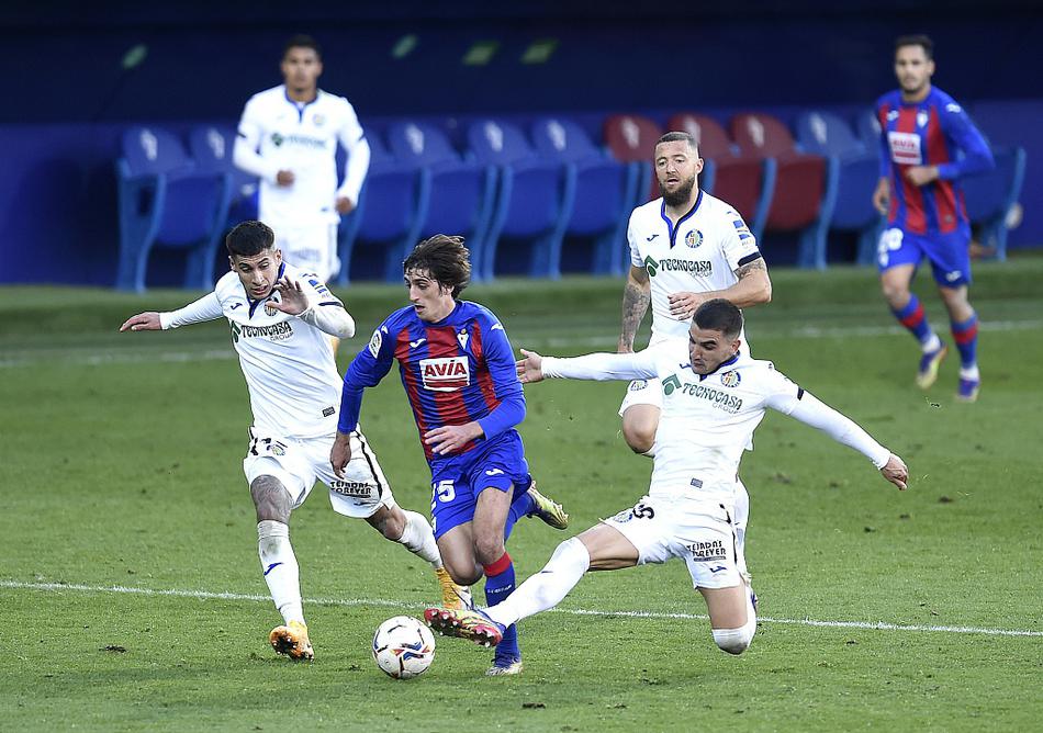 在伊普鲁阿市政球场的聚光灯下，埃瓦尔与赫塔菲的球员们在中场展开激烈缠斗，脚下的皮球成为双方寸土必争的焦点，空气中弥漫着西甲联赛特有的紧张与胶着。