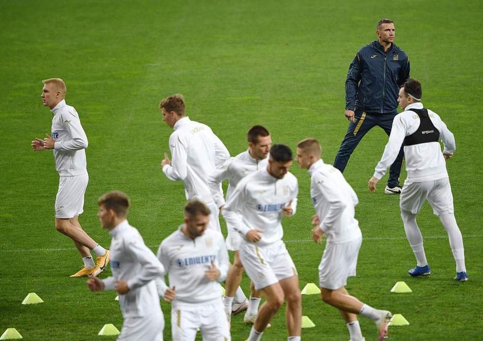 训练场上，几名乌克兰队员围成一个小圈进行‘抢圈’游戏。居中的球员奋力伸腿拦截，而圈外的队友则通过快速的一脚出球调动着他，欢声笑语中透露出团队间的默契与轻松氛围。