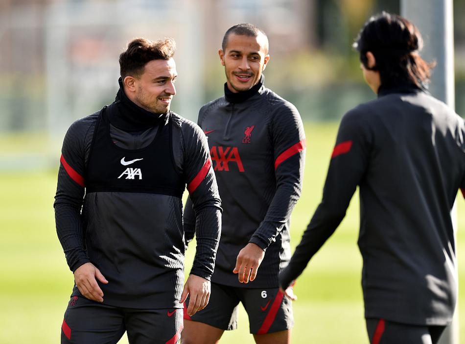 克洛普双手插兜，眼神专注地凝视着场内的一举一动，时而与身旁的助教交流，表情严肃而认真。