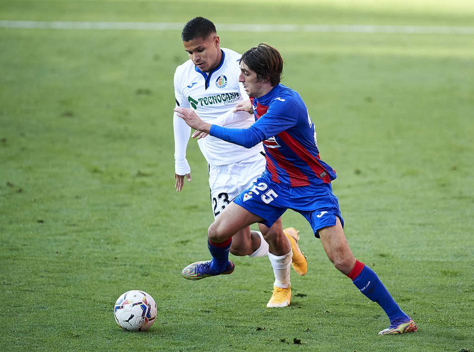 赫塔菲门将索里亚如雄鹰展翅般高高跃起，双拳将埃瓦尔开出的危险角球击出禁区，他身后的防守球员和对方争顶的前锋在那一刻仿佛都成了凝固的雕塑，画面充满力量感。