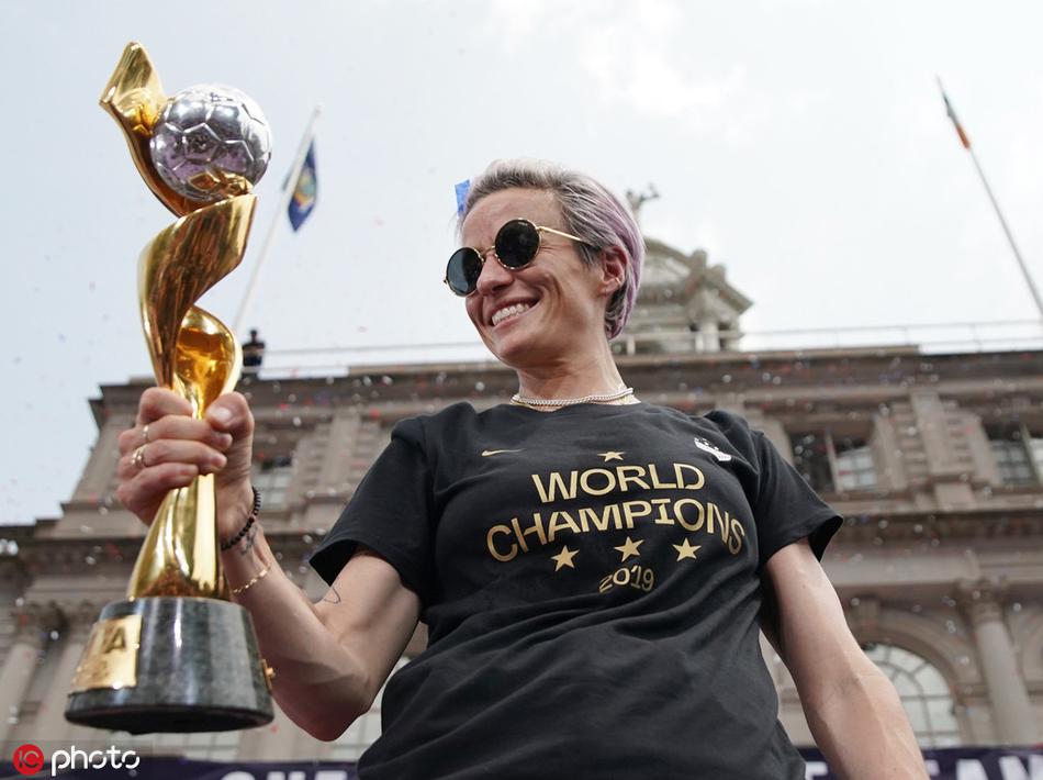 纽约市长白思豪现身花车，与美国女足队员们并肩而立，共同接受市民的欢呼与致敬，背景中曼哈顿下城的建筑轮廓清晰可见。