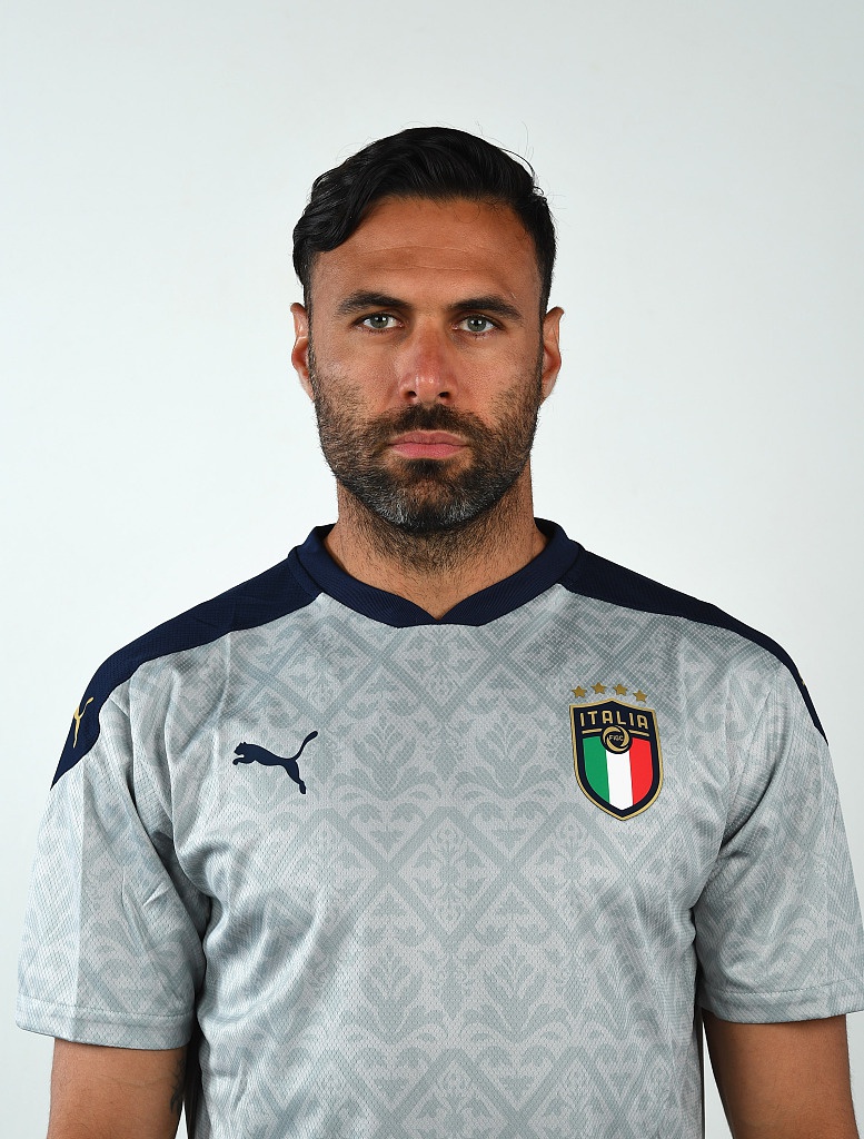 新星尼科洛·扎尼奥洛身穿训练服，眼神中带着一丝青涩却充满野心的光芒，预示着意大利足球未来的希望。