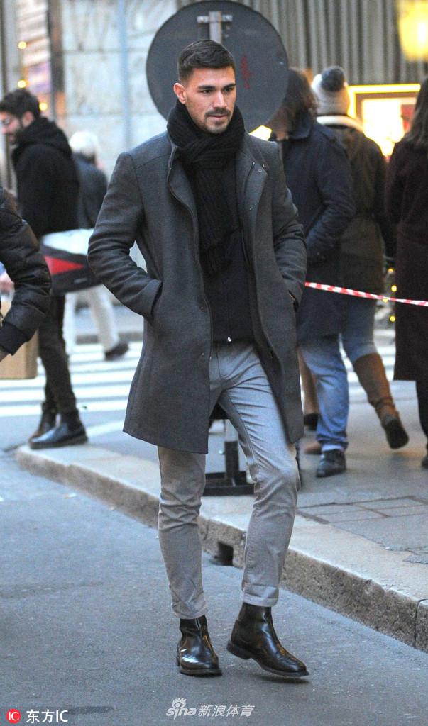 独自出行的罗马尼奥利双手插兜，脸上没有太多的表情，简单的白T恤和牛仔裤显得低调而随性。