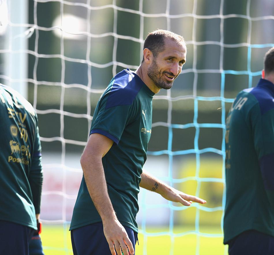 训练间隙，中场核心维拉蒂与后防领袖博努奇并肩而立，两人神情严肃地交流着。维拉蒂的手势似乎正在拆解对手的进攻线路，而博努奇则频频点头，这对组合的默契程度，将是意大利中场控制力的关键保障。