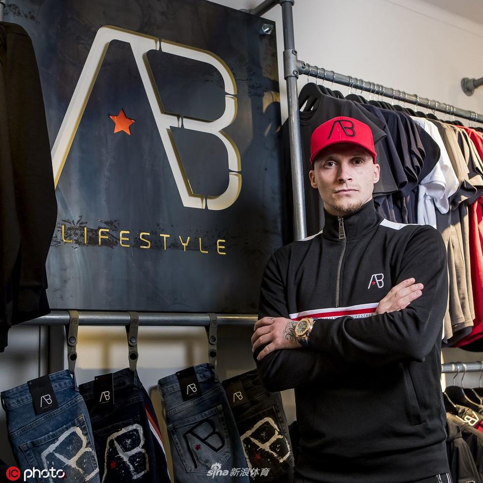 布特纳身着深色牛仔外套，眼神深邃，在杜廷赫姆街头展现成熟魅力。