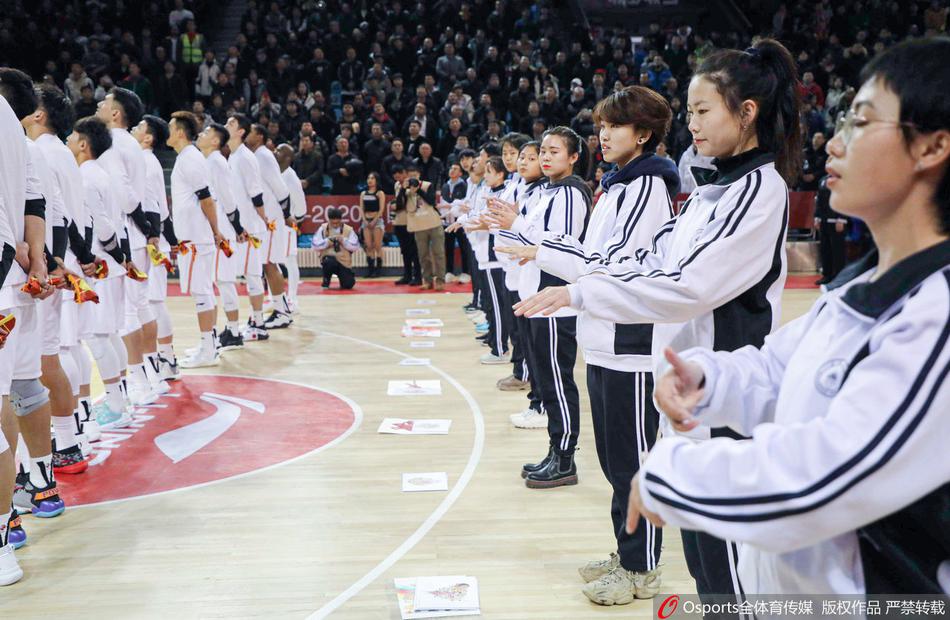 吉林队球员代表与听障学生们在场边互赠礼物，球员们弯腰俯身，学生们用手语表达着感谢，脸上满是喜悦与满足。