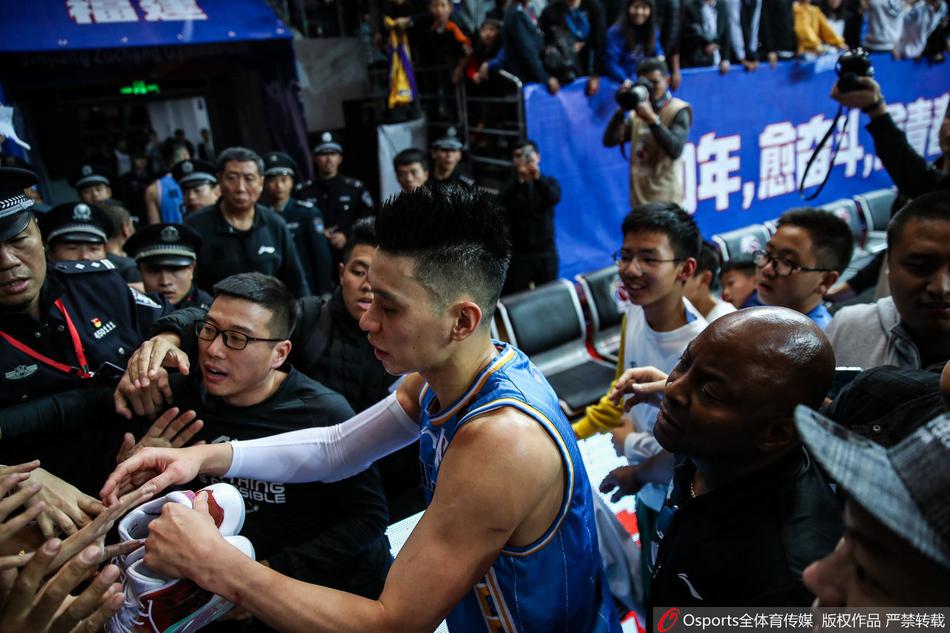 北京首钢队的核心林书豪运球过半场，他神情专注，目光如炬，正在观察场上队友的跑位。面对福建队的严密防守，他做出手势，示意队友跑动战术，展现出一名球队领袖应有的冷静与大局观。