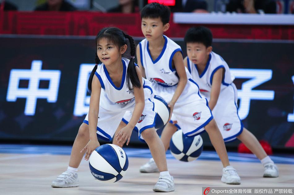 一名小球员在队伍中格外显眼，他紧咬着嘴唇，眼睛死死盯着手中的篮球，小手用力地拍着，动作虽然稚嫩却充满了力量感，那股不服输的倔强模样让人忍俊不禁。