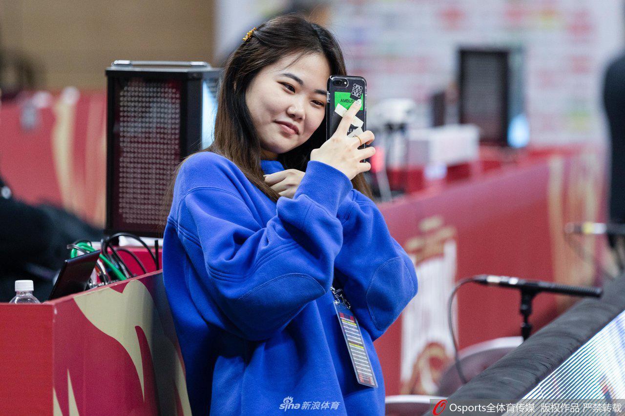 一位笑容灿烂的浙江美女球迷，对着镜头比出胜利的手势，尽管比赛胶着，但她脸上写满了对球队的信心，青春的活力与篮球的快乐在这一刻完美融合。