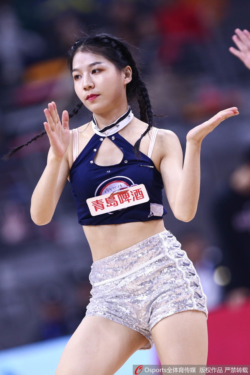 一位啦啦队宝贝在表演中展现出惊人的柔韧性与舞台表现力，她高抬腿的动作定格在空气中，专注的眼神和自信的微笑，完美诠释了当代篮球宝贝阳光健康的形象。