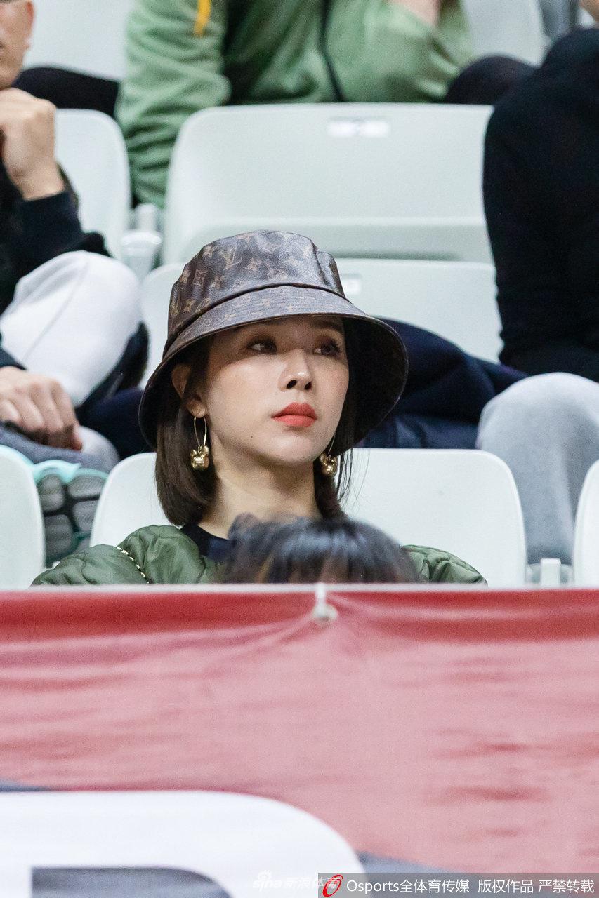 比赛结束后，一位新疆美女球迷在看台上展示一面小小的队旗，她的眼神中透着骄傲与满足，身后的客队区域成为欢庆的蓝色海洋，定格了这个属于新疆篮球的胜利之夜。