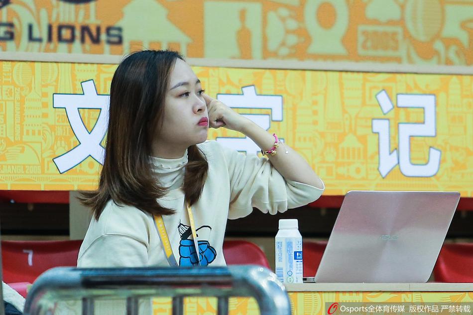 这位美女球迷长发如瀑，面带微笑地看着场上，即便在八一队大比分落后的时刻，她依然用温暖的笑容为场上的运动员加油鼓劲，展现了篮球赛场不仅有胜负，更有温情与热爱。