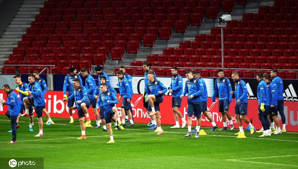 孔特拉双手叉腰伫立在寒风中，他的影子被灯光拉得细长，背后是渐暗的天色和整装待发的弟子，沉默的身影里藏着千言万语的战术布置。