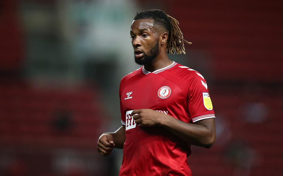 身穿红色球衣的克里斯·马丁在人群中高高跃起，他的额头精准地砸向飞来的皮球，身后的防守球员只能绝望地伸长手臂，背景里阿斯顿盖特球场的看台灯光将他进球的瞬间照耀得无比辉煌。