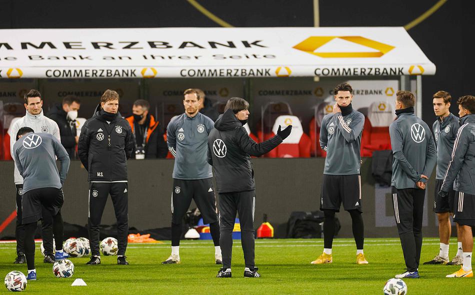 拉伸、压腿、蓄力。画面中，一名球员正进行着赛前的肌肉唤醒，他的身体在夕阳的余晖下拉出长长的影子，每一个静态的拉伸动作都如同芭蕾舞者在幕后的热身，优雅之下藏着即将爆发的惊人力量。