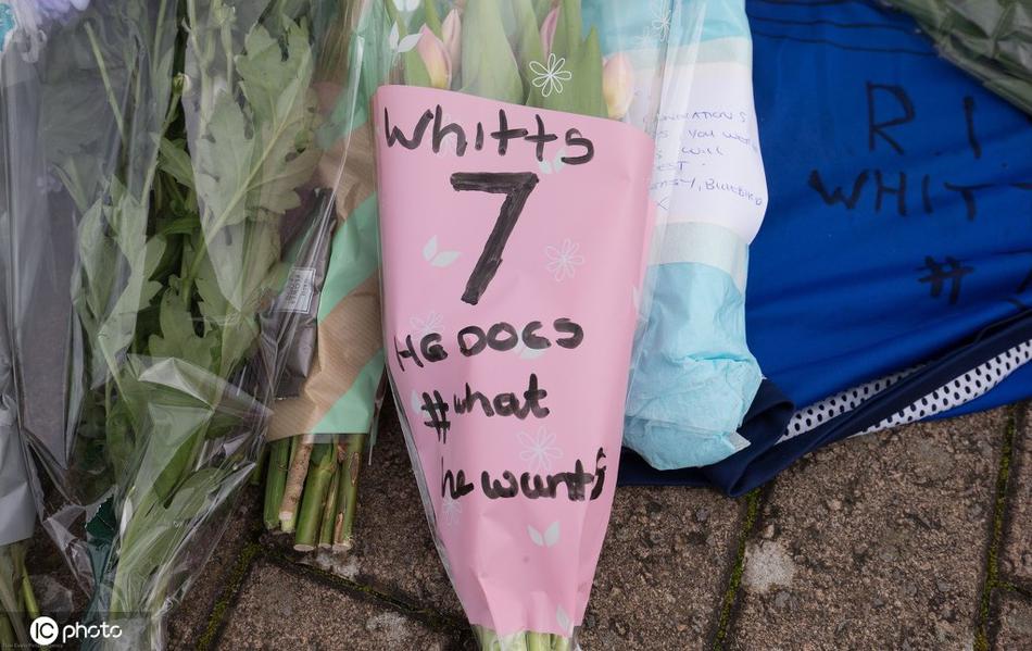 一位女球迷无法抑制内心的悲伤，倚靠在雕像前的护栏上掩面哭泣，她身旁的鲜花堆成了小山，每一朵都在诉说对于‘惠茨’突然离世的不舍与心痛。