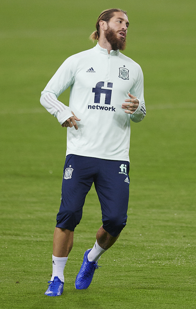 夕阳的余晖将训练场的草坪染成金色，一名球员独自加练任意球，他踢出的皮球划出一道美妙的弧线越过人墙，这一幕充满了力与美的视觉冲击。