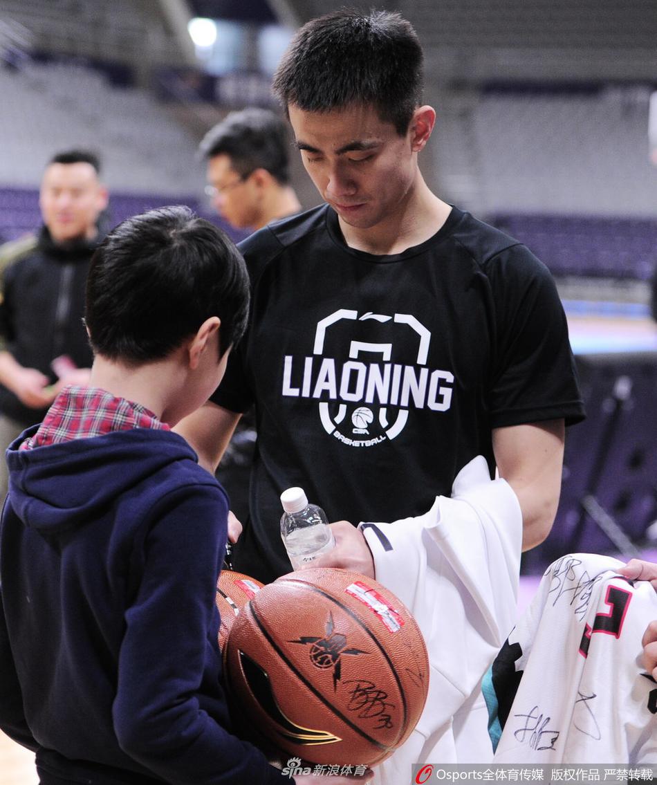 从高处俯拍的照片中，可见辽宁飞豹队球员正在场上进行对抗训练，而在场边的座椅旁，巴斯和赵继伟正抽空为趴在栏杆上的小球迷签名，赛场上的硝烟与场边的温情形成了鲜明对比。