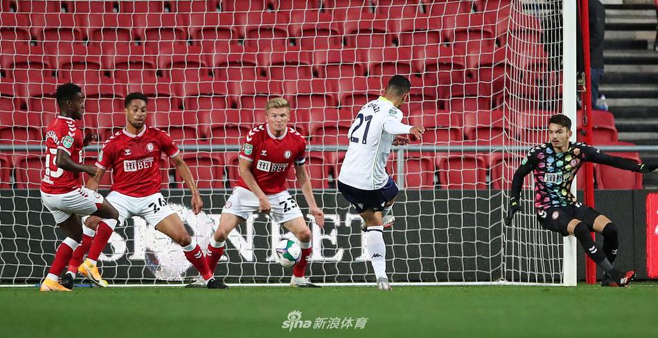 空无一人的阿斯顿盖特看台，绿色的座椅在灯光下显得格外寂静，无声地诉说着新冠疫情下足球比赛的特殊与不易。