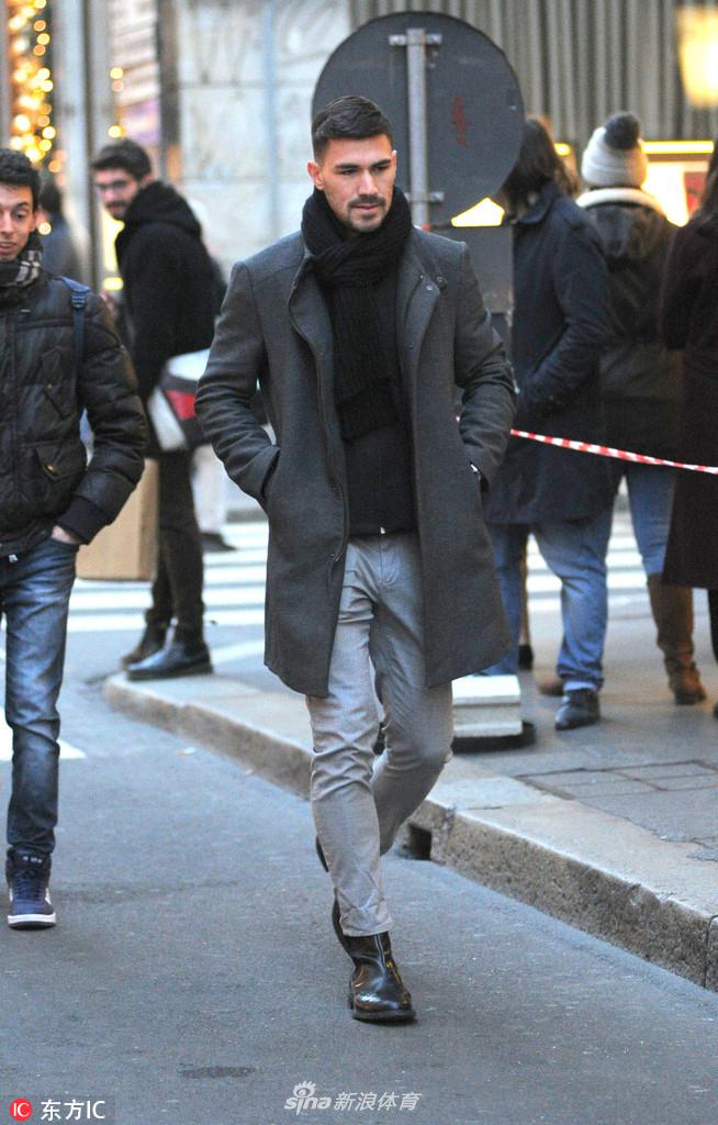 罗马尼奥利在米兰街头漫步，他微微低头似在沉思，周围是城市古老的建筑，衬托出他独行时的安静气质。